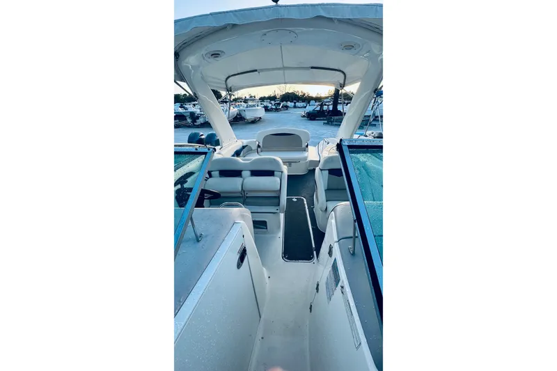 Slide: The Image of 2007 Chaparral 276 SSX boat interior with seating and canopy, docked outdoors. - 11
