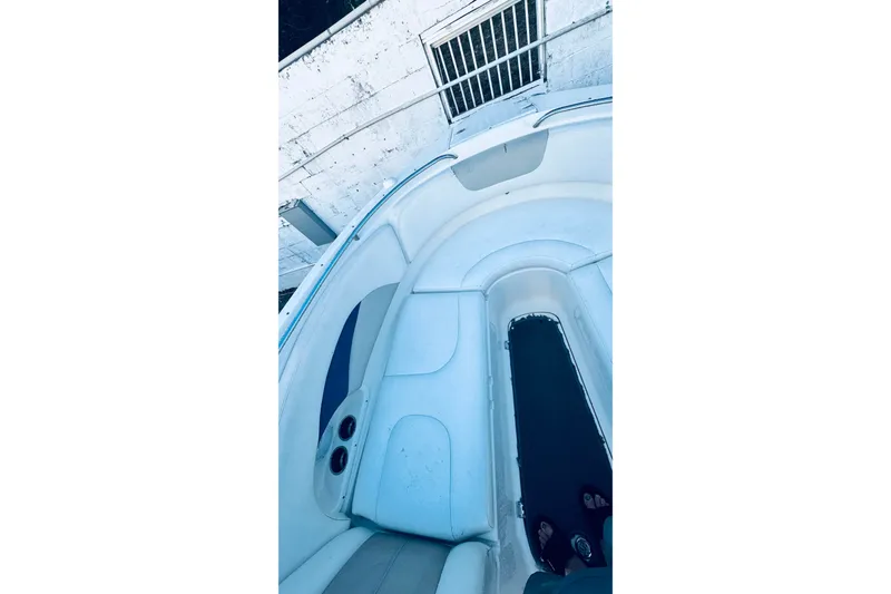 Slide: The Image of 2007 Chaparral 276 SSX boat interior with white seating and storage compartments. - 9