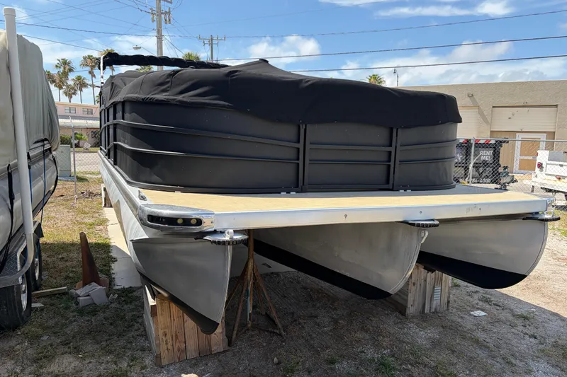 Slide: The Image of 2015 Premier 290 Grand View pontoon boat with black cover, stored outdoors. - 13