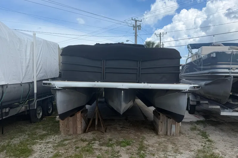 Slide: The Image of 2015 Premier 290 Grand View pontoon boat stored on blocks, covered, with other boats nearby. - 14