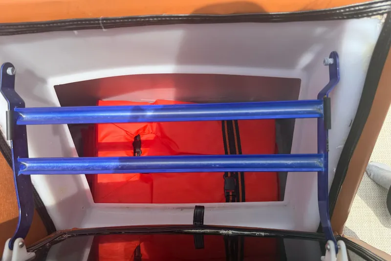 Slide: The Image of Interior view of a 2015 Premier 290 Grand View boat compartment with blue bars and red storage bag. - 77