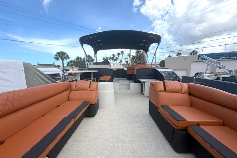 Slide: The Image of 2015 Premier 290 Grand View pontoon boat with spacious seating and canopy under a blue sky. - 26