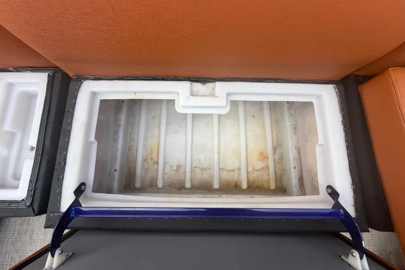 Slide: The Image of Open storage compartment in 2015 Premier 290 Grand View boat, featuring white interior and orange seating. - 51
