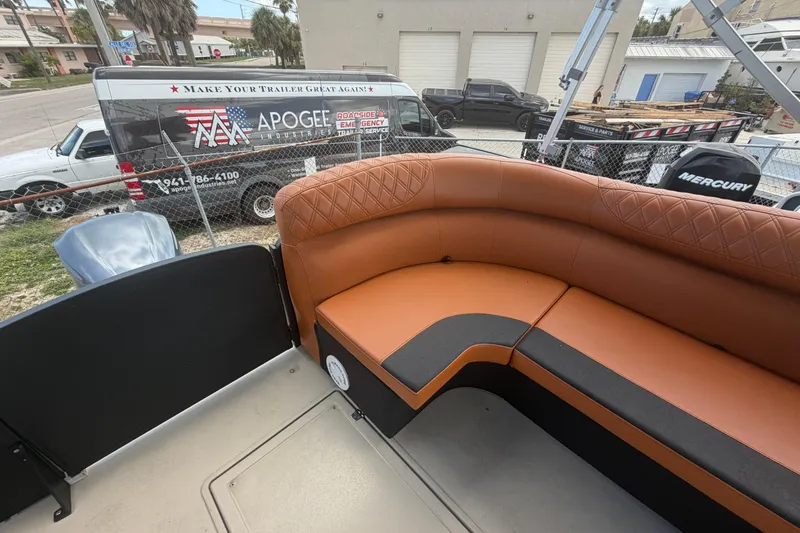 Slide: The Image of Premier 290 Grand View 2015 boat interior with tan seating, parked near service vehicles. - 30