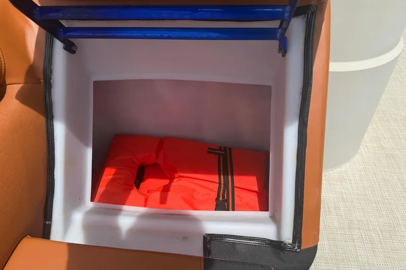 Slide: The Image of Storage compartment with orange life jacket on 2015 Premier 290 Grand View boat. - 57