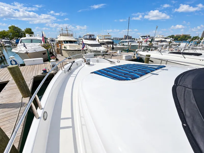 Slide: The Image of The image shows the deck of a 2002 Lazzara 80 Skylounge docked in a marina. - 32