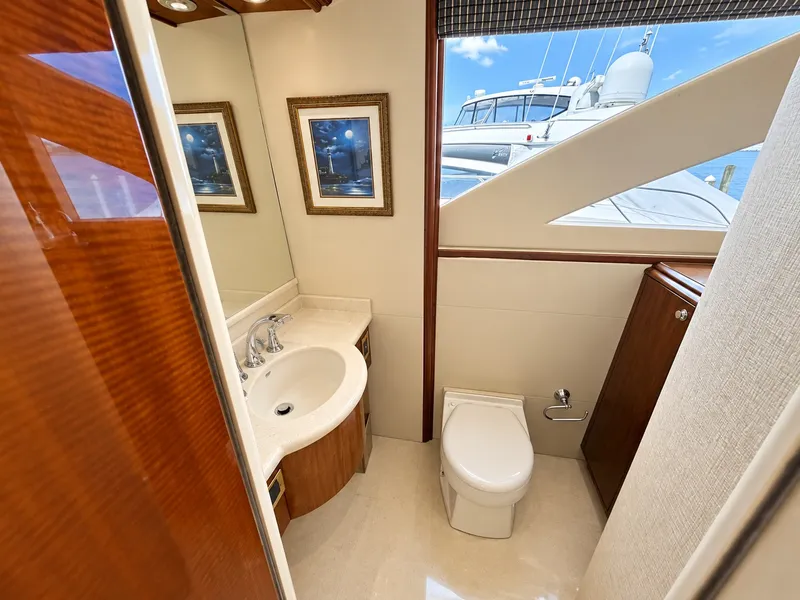 Slide: The Image of Luxurious bathroom with wood paneling, sink, toilet, and large window overlooking the water. - 44