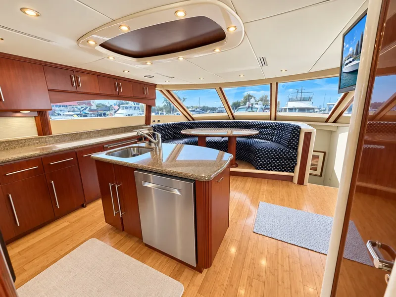 Slide: The Image of The 2002 Lazzara 80 Skylounge features an elegant kitchen with wood cabinets and a round dining area. - 38