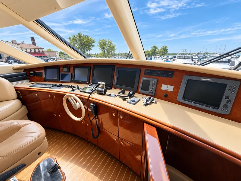 Slide: The Image of The cockpit of a 2002 Lazzara 80 Skylounge with multiple screens and a steering wheel. - 47