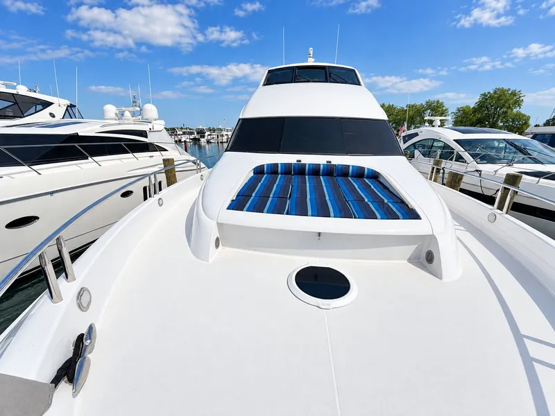 Slide: The Image of The 2002 Lazzara 80 Skylounge is docked at a marina. It features a sleek, modern design. - 29
