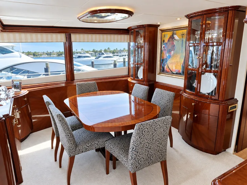 Slide: The Image of Elegant dining area with wooden table and upholstered chairs, surrounded by glass cabinets and artwork. - 36