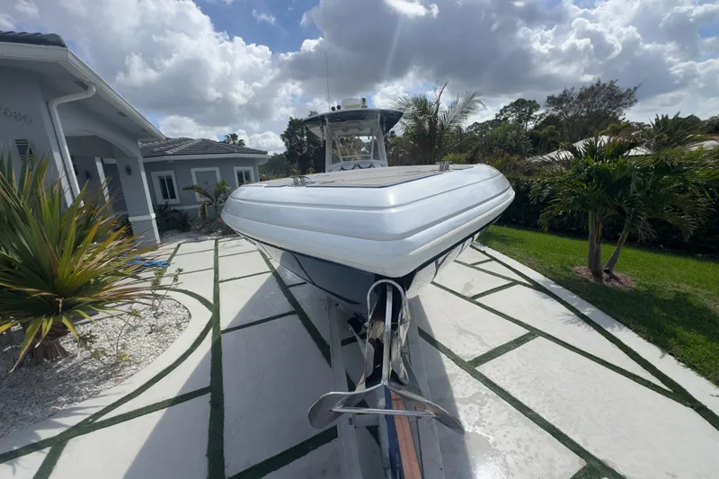 Slide: The Image of 2007 Intrepid 370 Center Console boat parked on a modern driveway with tropical landscaping. - 25