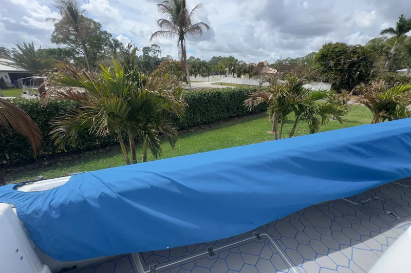 Slide: The Image of Covered 2007 Intrepid 370 Center Console boat with tropical landscape background. - 98