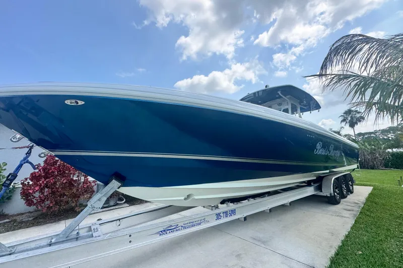 Slide: The Image of 2007 Intrepid 370 Center Console boat on trailer, parked outdoors under a partly cloudy sky. - 23