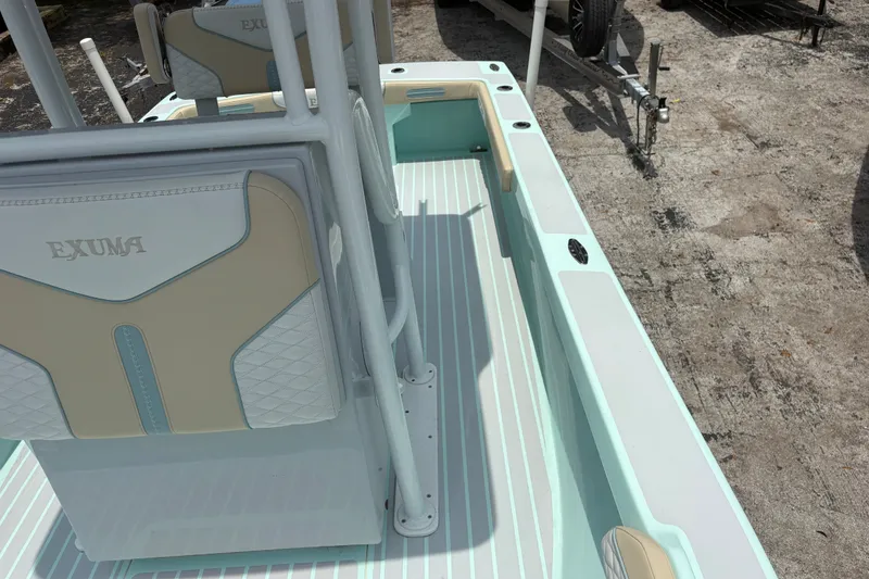 Slide: The Image of 2024 Exuma 22 boat interior with beige and white seating, docked on a trailer. - 26