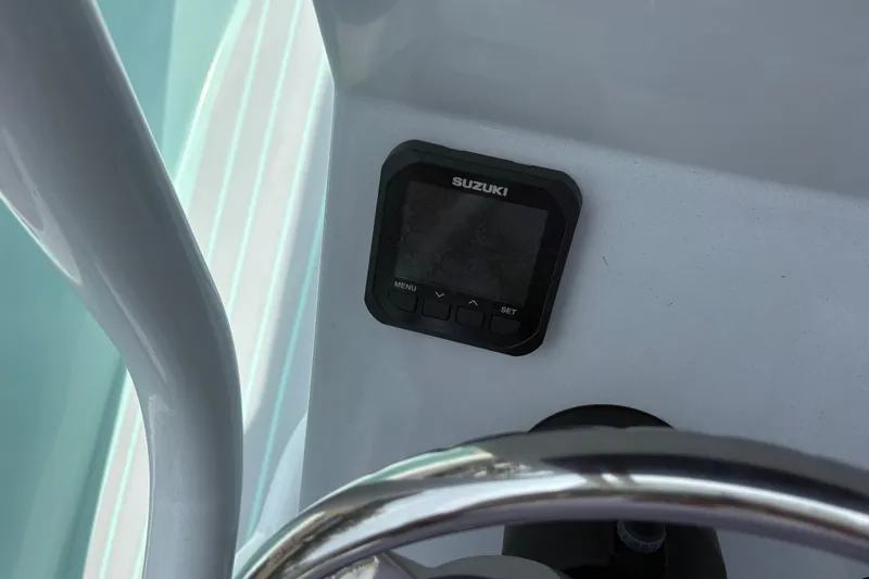Slide: The Image of Control panel on 2024 Exuma 22 boat with Suzuki display and steering wheel. - 19