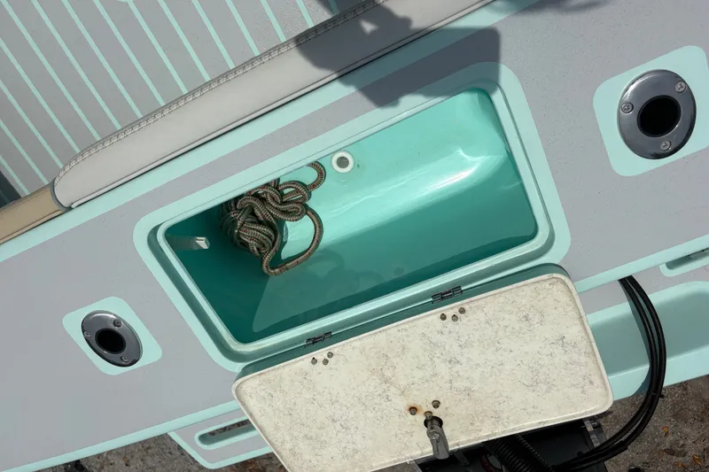 Slide: The Image of Open storage compartment on 2024 Exuma 22 boat with coiled rope inside. - 31