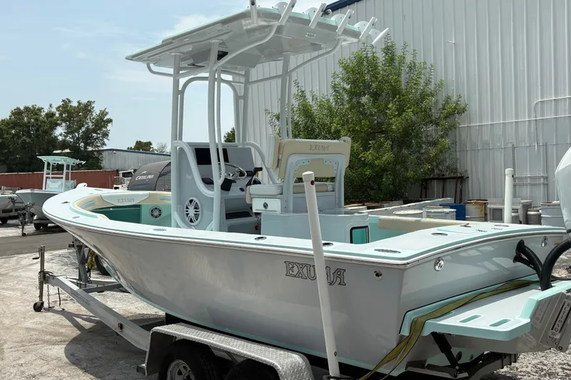 Slide: The Image of 2024 Exuma 22 boat on trailer, parked outdoors near industrial building. - 6