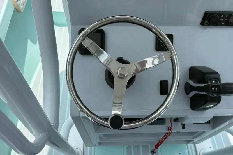 Slide: The Image of Steering wheel and controls of a 2024 Exuma 22 boat, showcasing modern design. - 16