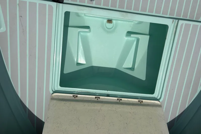 Slide: The Image of Open storage compartment on 2024 Exuma 22 boat, featuring a light teal interior. - 35