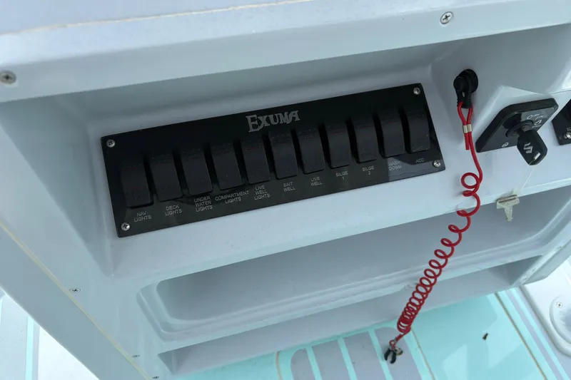 Slide: The Image of Control panel of 2024 Exuma 22 boat with labeled switches and ignition key. - 17