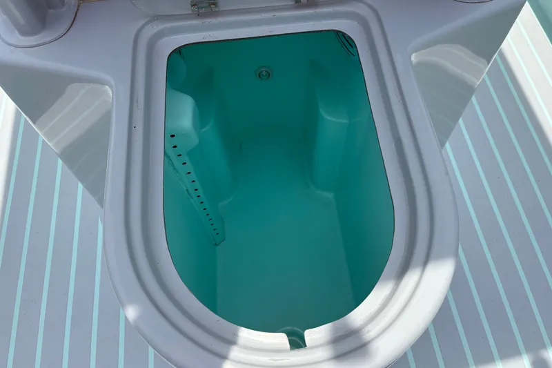Slide: The Image of 2024 Exuma 22 boat storage compartment with turquoise interior and striped deck. - 14