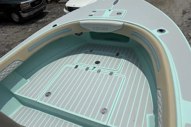 Slide: The Image of 2024 Exuma 22 boat interior with light blue and beige accents, featuring storage compartments. - 22