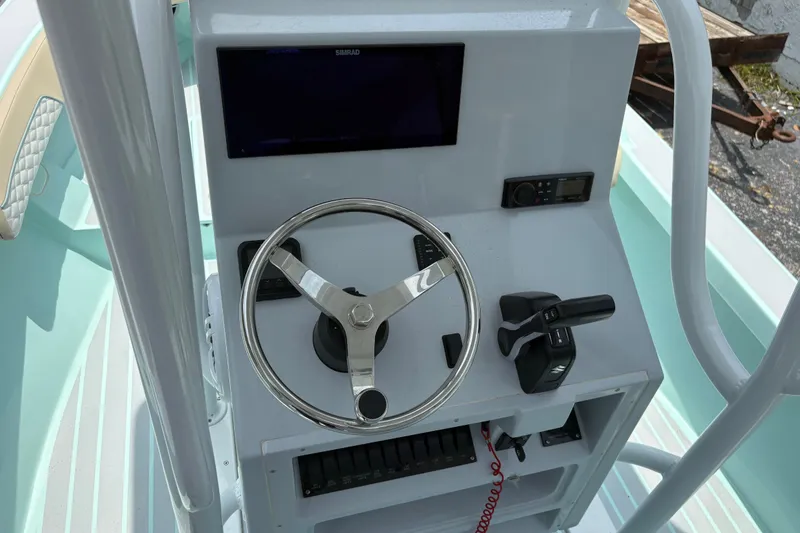 Slide: The Image of 2024 Exuma 22 boat console with steering wheel, controls, and navigation display. - 15