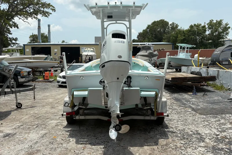 Slide: The Image of 2024 Exuma 22 boat with outboard motor on trailer in a boatyard setting. - 3