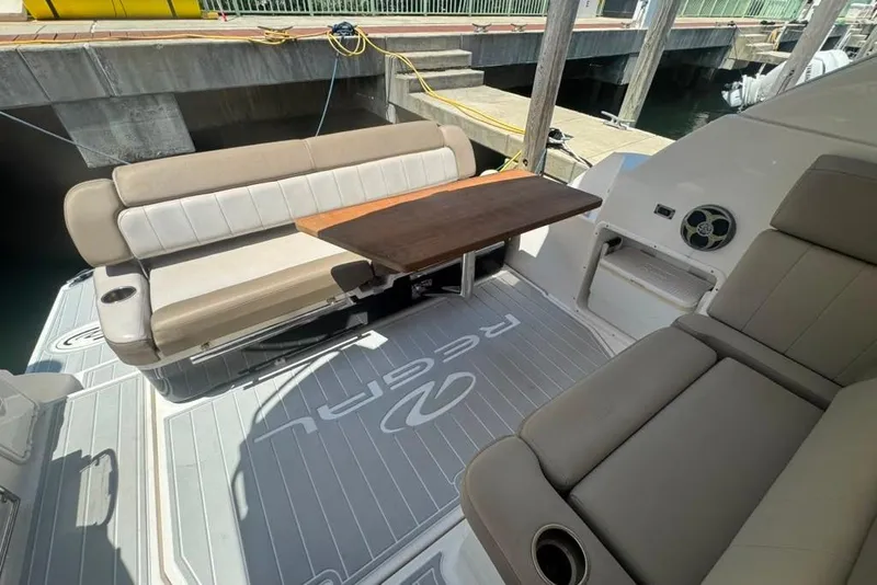 Slide: The Image of La imagen muestra la cabina de un Regal 35 Sport Coupe 2015 con asientos beige y una mesa de madera. - 24