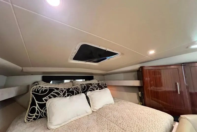 Slide: The Image of Luxurious cabin interior of 2015 Regal 35 Sport Coupe with elegant bedding and wooden cabinetry. - 44