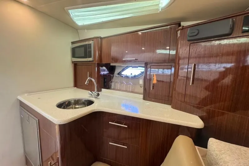 Slide: The Image of De kombuis van de Regal 35 Sport Coupe 2015 heeft een gootsteen, magnetron en houten kasten. - 35