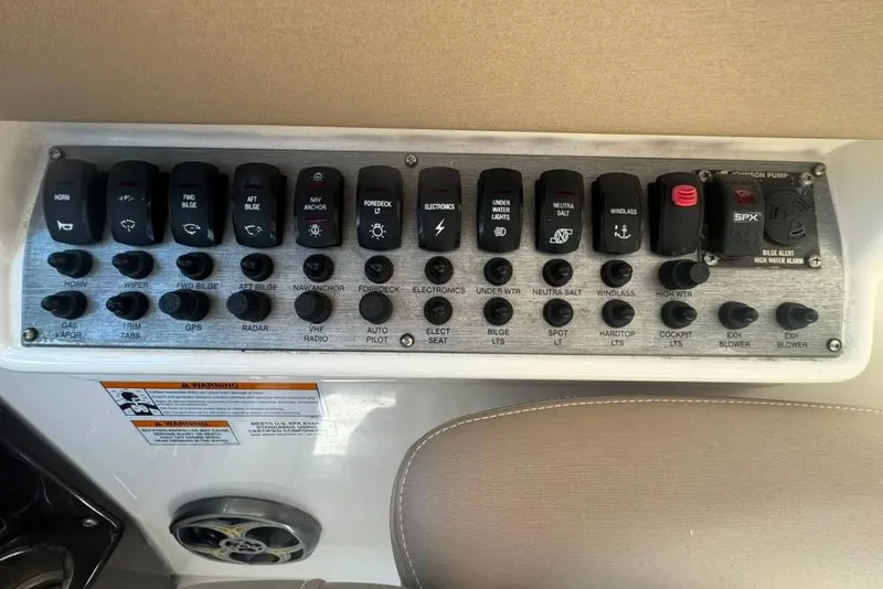 Slide: The Image of Control panel of a 2015 Regal 35 Sport Coupe boat with labeled switches and buttons. - 77