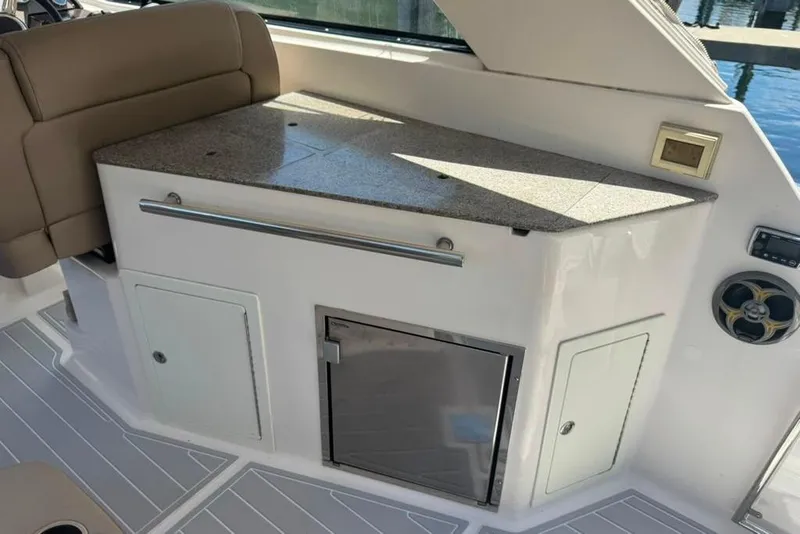 Slide: The Image of Interior of a 2015 Regal 35 Sport Coupe with kitchenette and seating area. - 30