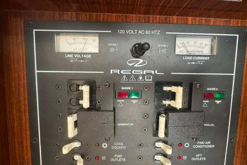 Slide: The Image of Control panel of a 2015 Regal 35 Sport Coupe, showing line voltage and load current gauges. - 79
