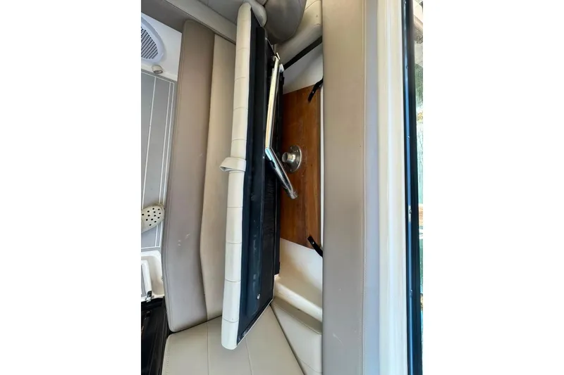 Slide: The Image of Interior view of a 2015 Regal 35 Sport Coupe, featuring seating and a foldable table. - 86