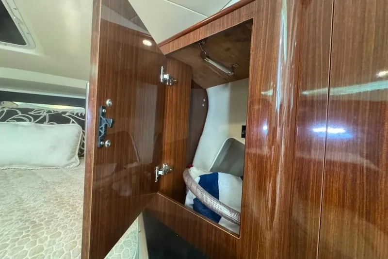 Slide: The Image of Open wooden cabinet in 2015 Regal 35 Sport Coupe interior, revealing storage space. - 89