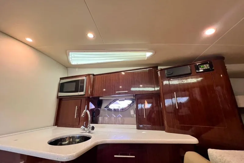 Slide: The Image of Die Innenansicht einer Regal 35 Sport Coupe von 2015 zeigt eine elegante Küche mit Holzschränken und einem Waschbecken. - 49