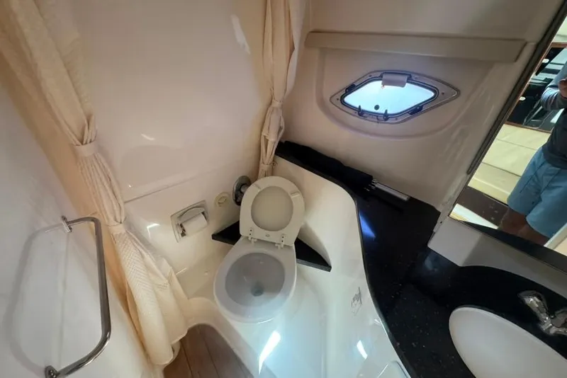 Slide: The Image of Bathroom interior of 2015 Regal 35 Sport Coupe with toilet, sink, and porthole window. - 85