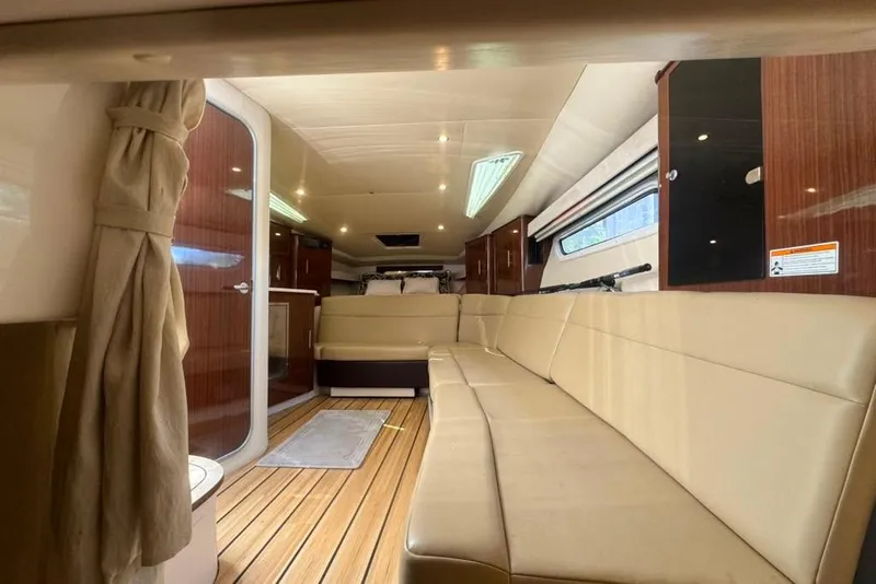 Slide: The Image of Luxurious interior of a 2015 Regal 35 Sport Coupe yacht with beige seating and wood accents. - 47