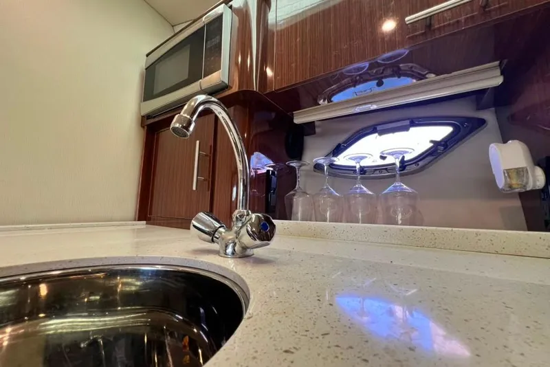 Slide: The Image of Luxurious kitchen area in a 2015 Regal 35 Sport Coupe yacht with modern amenities. - 73