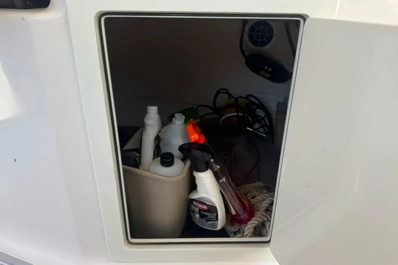 Slide: The Image of Storage compartment on a 2015 Regal 35 Sport Coupe with cleaning supplies and ropes. - 72