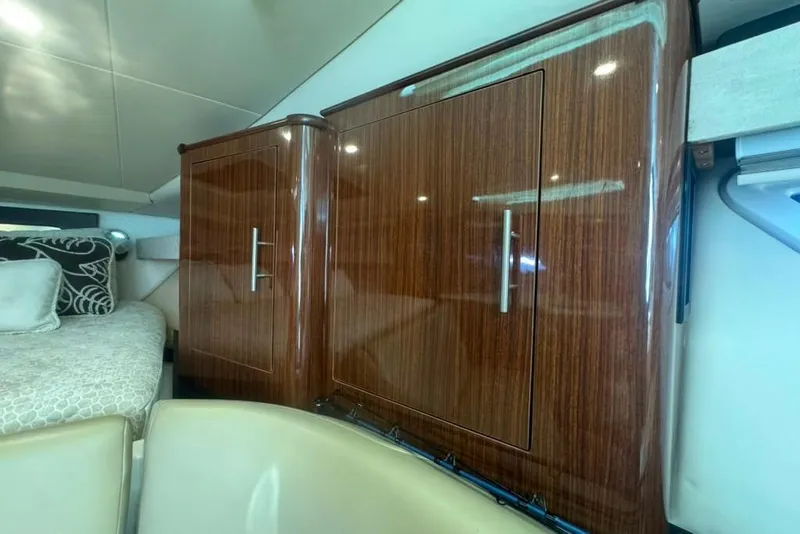 Slide: The Image of Interior of 2015 Regal 35 Sport Coupe with wooden cabinetry and cozy bedding. - 54