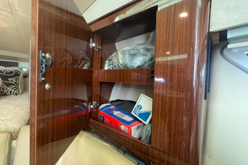 Slide: The Image of Open wooden cabinet in 2015 Regal 35 Sport Coupe, storing various items. - 78