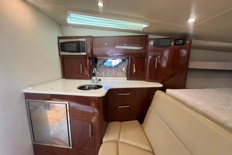 Slide: The Image of La cabina interna di un Regal 35 Sport Coupe 2015 presenta una cucina compatta con armadietti in legno, lavello e microonde. - 37