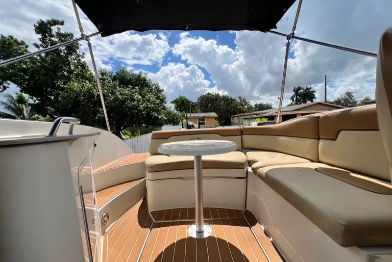 Slide: The Image of 2007 Sea Ray 260 Sundeck interior with seating and table under canopy, sunny day. - 33