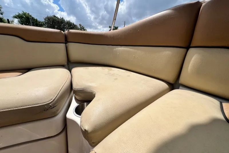 Slide: The Image of 2007 Sea Ray 260 Sundeck interior seating with beige upholstery under a cloudy sky. - 28