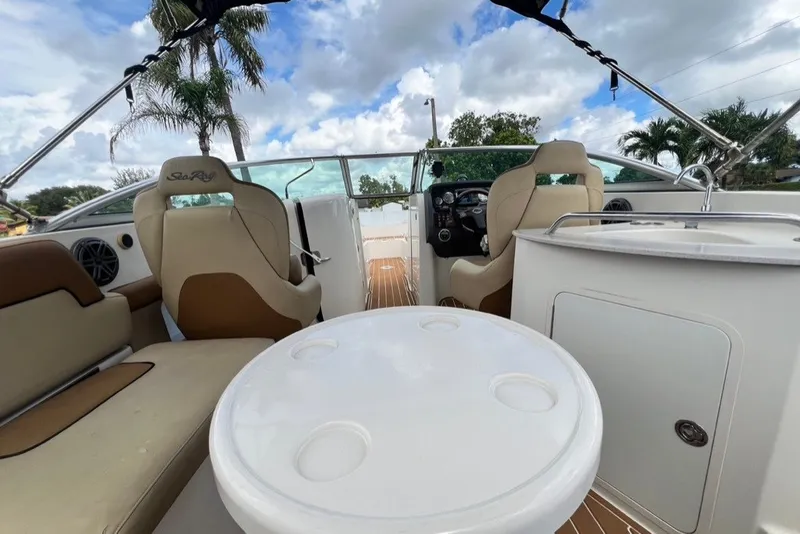Slide: The Image of 2007 Sea Ray 260 Sundeck interior with seating, table, and steering wheel under a blue sky. - 73