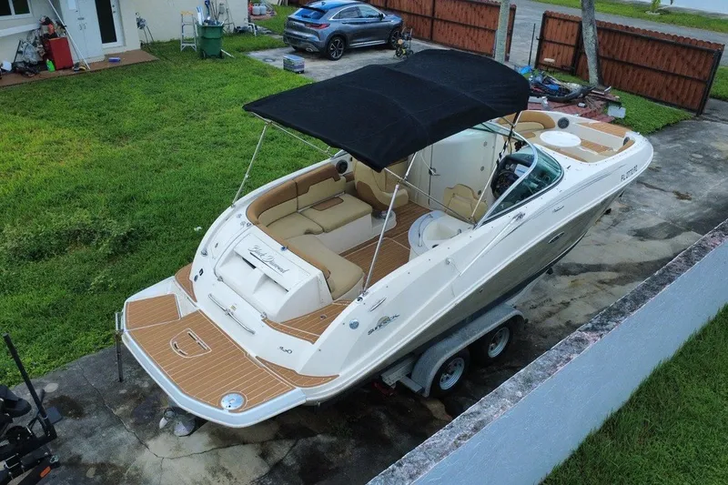 Slide: The Image of 2007 Sea Ray 260 Sundeck boat with black canopy on trailer in driveway. - 9