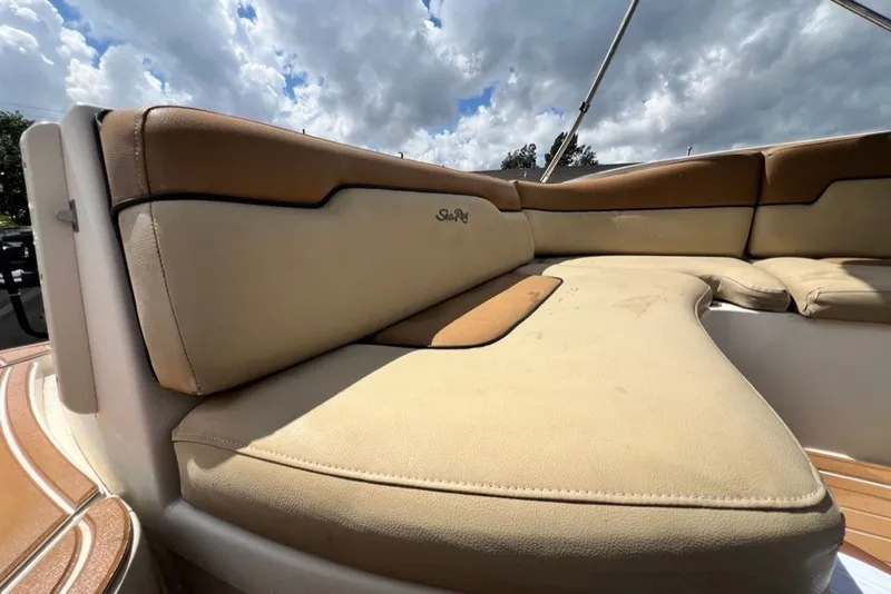 Slide: The Image of 2007 Sea Ray 260 Sundeck boat interior with tan seating under cloudy sky. - 17